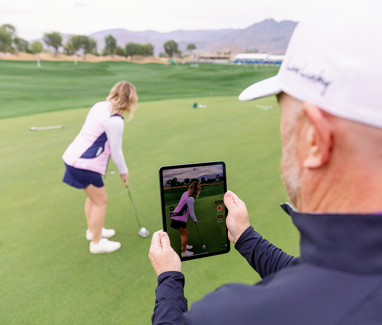 instructor photographing golfer